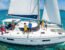 A diverse group joyfully sails a large white catamaran named "SEA ROVER" on clear turquoise Caribbean waters under bright sun.